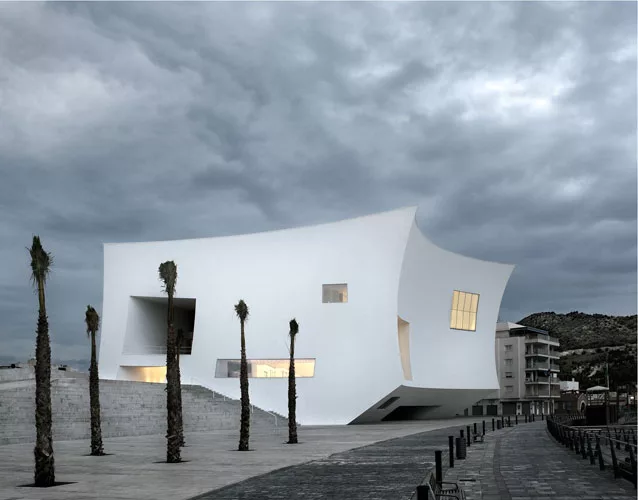 For a town on Spain's Mediterranean coast, the architects created a compact volume to minimize its occupation of the waterfront, and to create a point of reference in the landscape. The concave walls,