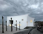 For a town on Spain's Mediterranean coast, the architects created a compact volume to minimize its occupation of the waterfront, and to create a point of reference in the landscape. The concave walls,