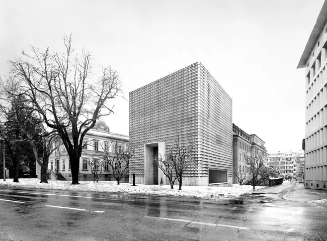The galleries for this art museum addition in Chur, Switzerland, are underground, to conserve the existing garden, with its exotic plants and trees. The freestanding new structure houses the entry, of