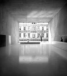 The galleries for this art museum addition in Chur, Switzerland, are underground, to conserve the existing garden, with its exotic plants and trees. The freestanding new structure houses the entry, of