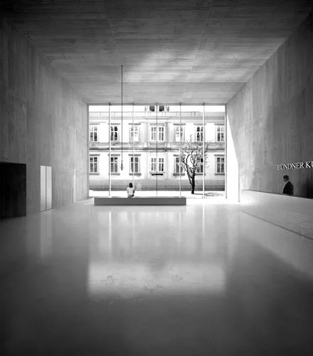 The galleries for this art museum addition in Chur, Switzerland, are underground, to conserve the existing garden, with its exotic plants and trees. The freestanding new structure houses the entry, of