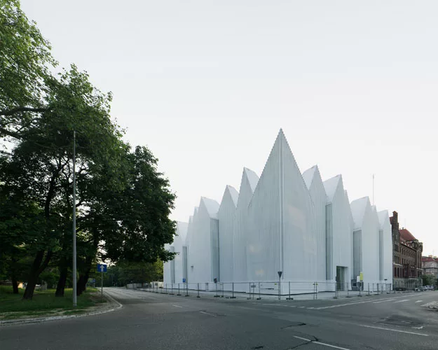 Occupying the site of a concert hall destroyed during World War II in this northwestern Polish city, the building's translucent glass form 'appears as a white mass in the daytime,' says Alberto Veiga,