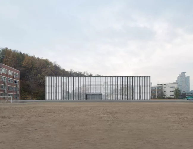 Scheduled to be completed at the end of 2014, this 28,000-square-foot high school responds to different conditions on its three sides by presenting three different facades. Facing a playground to the