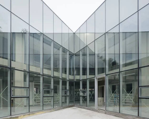 Scheduled to be completed at the end of 2014, this 28,000-square-foot high school responds to different conditions on its three sides by presenting three different facades. Facing a playground to the
