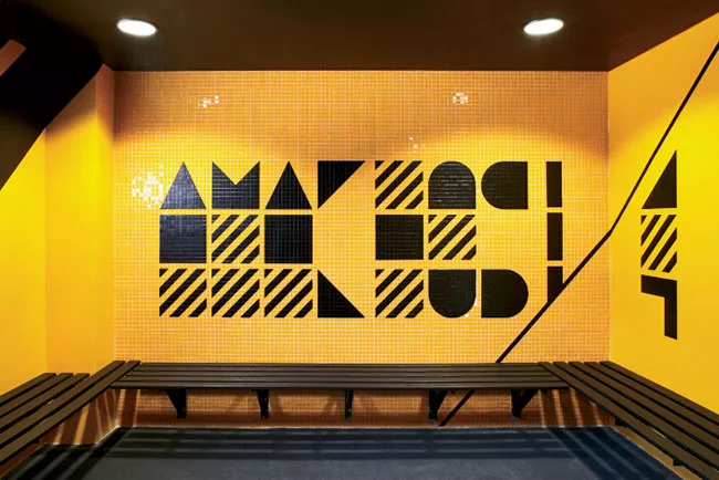 In a renovated structure behind the new building, RUFproject worked with the graphic design agency Grid Worldwide to stamp each dressing room with the logos and colors of famous football teams sponsor