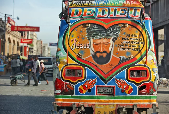 The back of a 'tap tap,' or private bus, in downtown Port-au-Prince. Many of the vehicles look similar in style and generally convey a religious sentiment. <em>January 2012</em>.