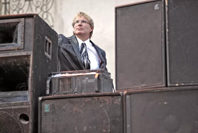 An American preacher prepares to give a sermon to a small gathering of Haitians. <em>January 2012</em>.