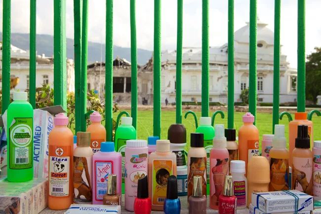 For-sale beauty products line a wall surrounding the crumbled Presidential Palace. <em>April 2010</em>.