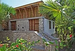 The building is partly shaded by palm trees.