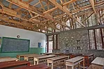 Openings covered with locally fabricated bamboo screens help ventilate the two-classroom building.