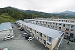 Quick to construct (and deconstruct), the buildings consist of shipping containers stacked and secured by a steel frame. For insulation and seismic resistance, they are arranged in a checkerboard patt