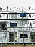 Quick to construct (and deconstruct), the buildings consist of shipping containers stacked and secured by a steel frame. For insulation and seismic resistance, they are arranged in a checkerboard patt