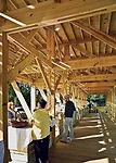 A wooden ramp provides access inside, where custommade wood counters line a central aisle delineating vendor space from public areas.