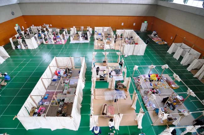 Emergency centers set up in gymnasiums and other large structures offer little privacy. In response, Shigeru Ban conceived a partition system made of paper tubes and canvas sheets.