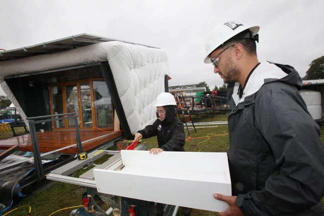 Rinaldo Perez, right, and Lanna Semel, center, help assemble <em>CHIP</em>, the house designed by SCI-Arc and Caltech.