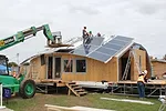 The University of Calgary team installs solar panels on the roof of its house, <em>TRTL</em> (Technological Residence, Traditional Living). 
