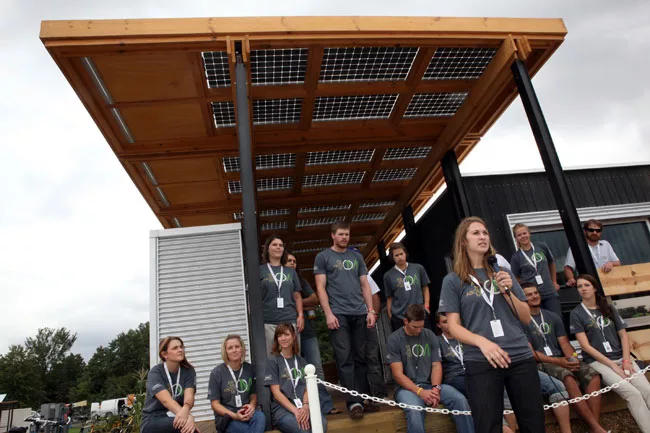 Chelsea Royall, front, team design director of Appalachian State University, talks about her team's house'<em>The Solar Homestead</em>'during a media preview on September 21. 