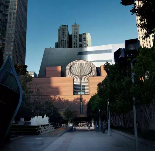 The roofline of Sn'hetta's new building dips just behind Mario Botta's 1995 building. The new volume will be inserted in the interior of the block just behind the original structure.