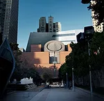 The roofline of Sn'hetta's new building dips just behind Mario Botta's 1995 building. The new volume will be inserted in the interior of the block just behind the original structure.