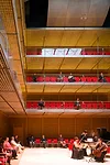 Musicians play on the floor of the box-like performance hall.