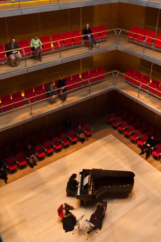 Narrow balconies wrapping the performance space afford views of musicians below as well as other concertgoers.