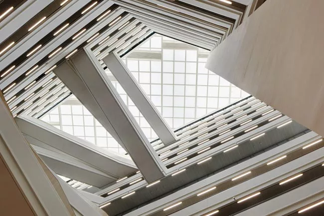A full-height atrium features a transparent roof to allow ample daylight into the building. 