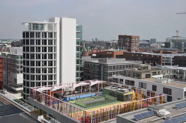 Katharinenschule school, designed by local firm Spengler & Wiescholek, features a colorful play area on the roof. The adjacent white Elipse tower is part of the Coffee Plaza, three office buildings co