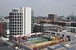Katharinenschule school, designed by local firm Spengler & Wiescholek, features a colorful play area on the roof. The adjacent white Elipse tower is part of the Coffee Plaza, three office buildings co