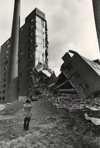 One of Pruitt-Igoe's 33 buildings stands half-demolished.