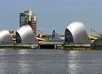 The Thames Barrier protects London. Designed by Rendel, Palmer and Tritton, the barrier consists of nine concrete piers and gates stretching 1,700 feet across the river. The piers house hydraulic mach