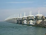 The Oosterscheldekering (Eastern Scheldt Storm Surge Barrier) is the largest of 13 structures making up the Delta  Works that protect southern Holland. The Delta Works were initiated in response to th
