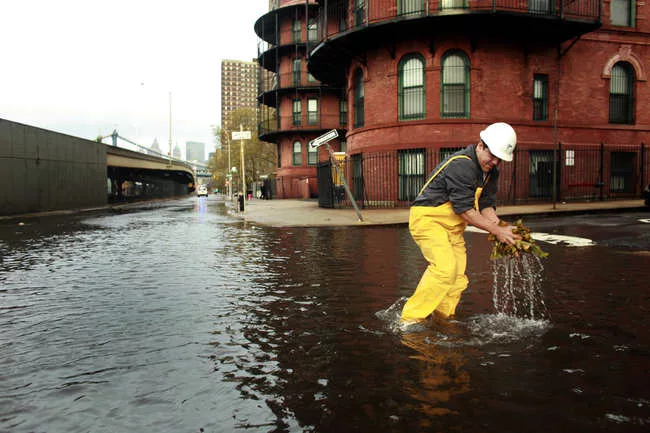 <p>A New York City worker clears a sewer drain in Lower Manhattan after Superstorm Sandy.</p>