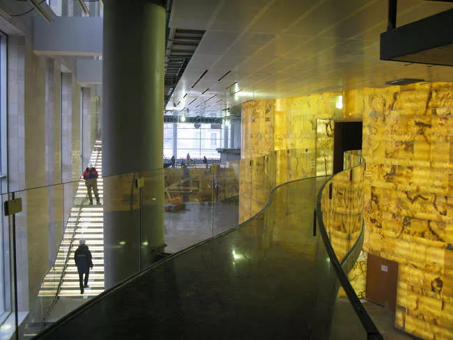 The Mariinsky II lobby during construction, showing the glass stair (right), bridge to the V.I.P. box (center), and back-it onyx wall that envelopes the performance hall.