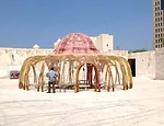 A tent made from a nest of red and orange polyester cable, <em>Enquant a cultural nos separa, a natureza nos une [While Culture Moves Us Apart Nature Brings Us Together]</em>, 2013, by Brazilian artis