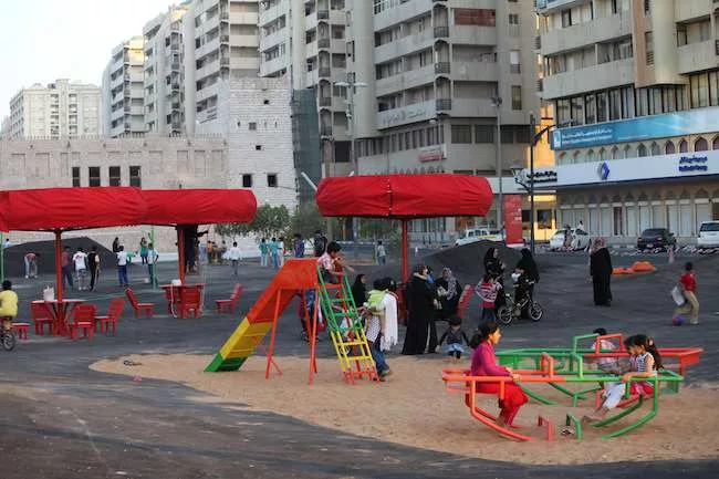 Unfortunately, Superflex placed its playground swings, benches, volleyball court, and other objects on a sea of asphalt running through the middle of a boulevard. The material retains daytime heat wel