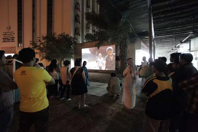 <p>Both foreign visitors and locals converge on an ad-hoc outdoor theater screening work by the Indian collective Camp. To make <em>From Gulf to Gulf to Gulf</em>, 2009-13, the artists gave cameras to