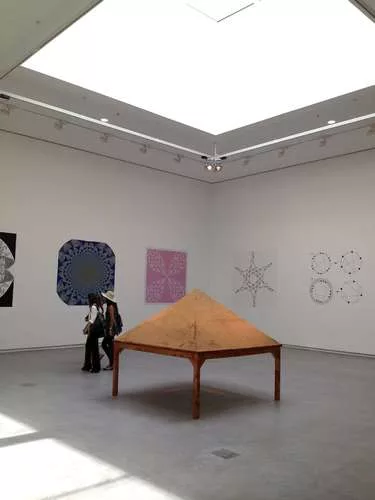 Inside, the galleries bring in daylight through shaded skylights, clerestories, and full-height windows. At left, Gabriel Orozco’s <em>Sand on Table as Model of “Self-organizing Criticalit