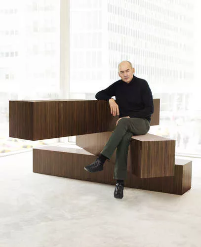Rem Koolhaus sits on his 04 Counter, a rotating partition-cum-seating area from his Tools for Life collection for Knoll.