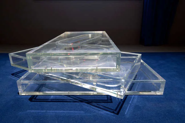 A coffee table from the Tools for Life collection from Knoll is a stack of three transparent boxes constructed of clear acrylic.