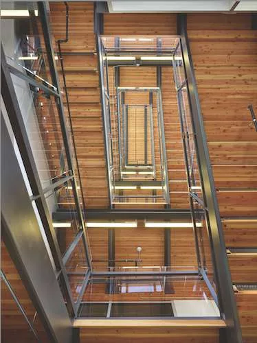 With the goal of making the stairs a more attractive option than the elevator, the design team created an “irresistible stair” with wood treads and glass balustrades.