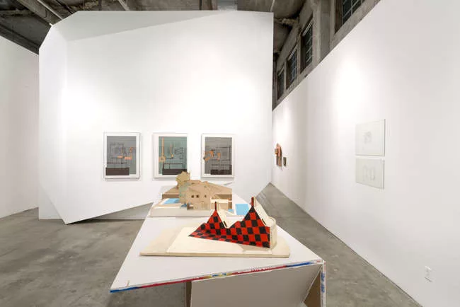 Eric Owen Moss' unrealized <em>Fun House</em> (1980), as it appears in a vintage model, plays semi-severed sculptural forms against a graphic wrap. On the wall, Morphosis' <em>Sixth Street House</em> 