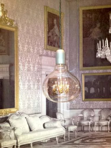 <strong>At ICFF</strong><br /> A dollhouse-size chandelier embedded in a lightbulb-shaped hanging lamp by Mineheart, based in England. The company also designs wallpaper, as seen in the background of 