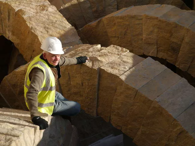 Artist Andy Goldsworthy working on Stone Sea, a permanent installation of 25 limestone arches in a space between the museum’s Main and East Buildings.