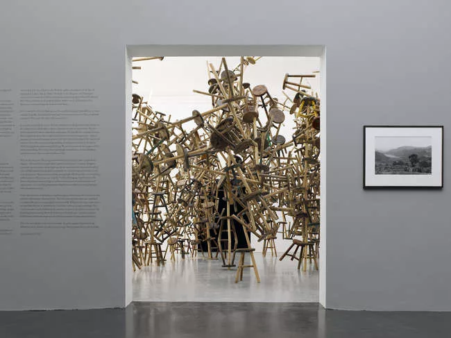 Ai Weiwei's <em>Bang</em> (seen through the doorway) and (right) Santu Mofokeng's print <em>Lake Funduzi, Venda (South Africa)</em>, 2011.