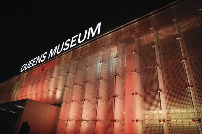 The west facade of the renovated Queens Museum features glass panels illuminated with programmable LED lighting.