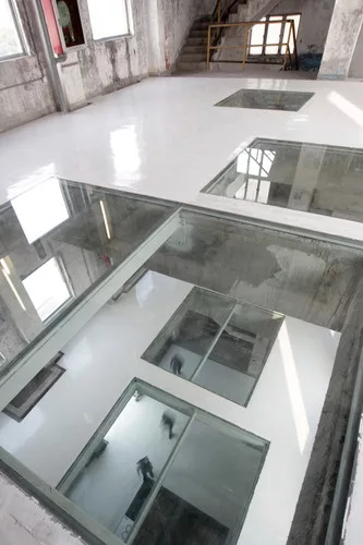Inside the Silo Building, O-office Architects cut out rectangles in the  floors and covered them with glass, creating remarkable views through  the structure.