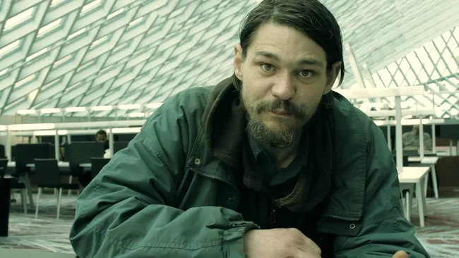 <p>Film Still from <em>REM</em>:</p><p>A homeless man takes refuge in OMA’s Seattle Public Library</p>