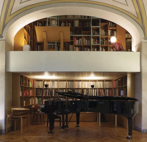Mario Bellini's Milan home, in a 19th century building reworked by Piero Portaluppi, is designed around a large library/staircase, which runs through and across it.
