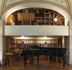 Mario Bellini's Milan home, in a 19th century building reworked by Piero Portaluppi, is designed around a large library/staircase, which runs through and across it.