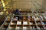 Mario Bellini's Milan home, in a 19th century building reworked by Piero  Portaluppi, is designed around a large library/staircase, which runs  through and across it.